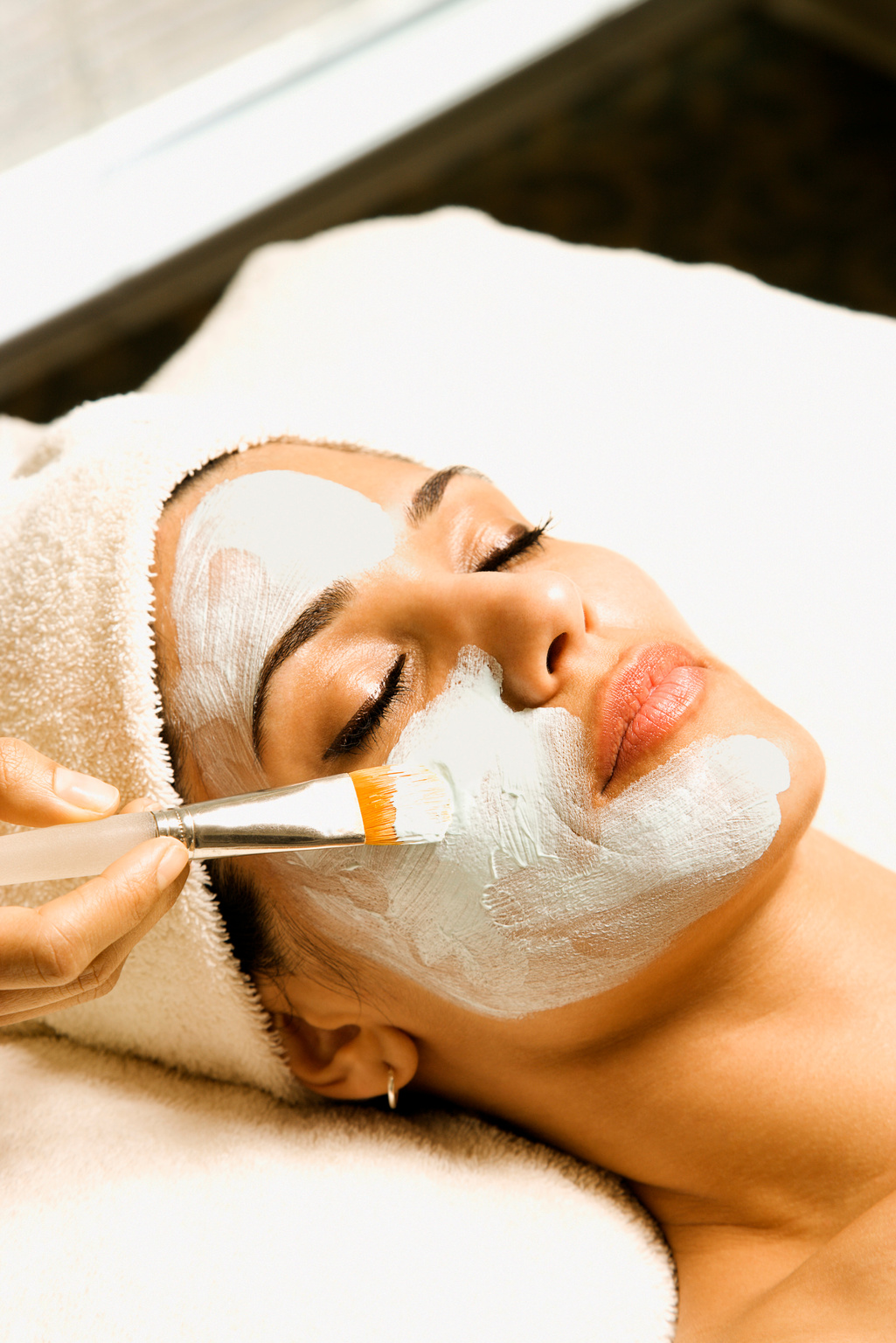 Woman receiving facial treatment at spa